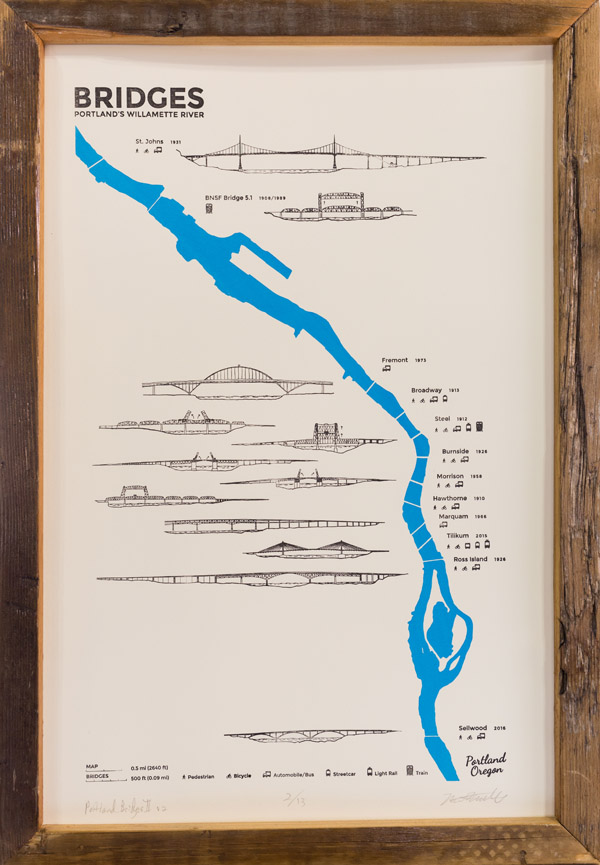 A look at one of the maps on the table. A wide blue line shows a river. Along its length, there are small gaps in the river. Each gap is labeled with a name and drawing of a bridge, in black. The map is titled 'Bridges: Portlands Willamette River.' Photo by Charles P. Rader.