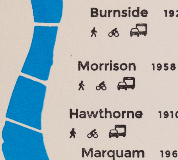 A more detailed image of the map. A blue ink line has several small linear interruptions running across it. Each is labeled with in black with the name of a bridge, along with icons of vehicles, people, and cyclists. Photo by Charles P. Rader.